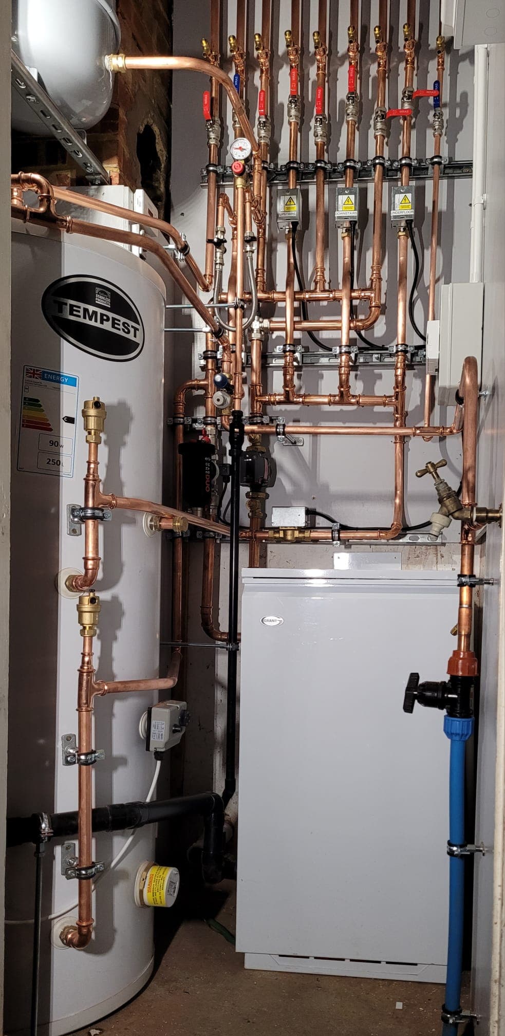 Compact plant room with Tempest unvented cylinder and a symmetrical copper manifold, fully clipped and labelled